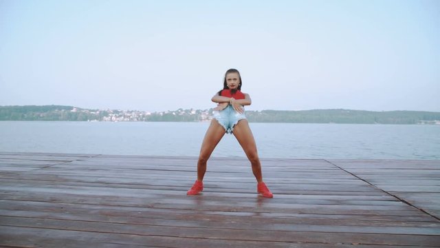 Attractive girl dancing hip-hop on the beach in 4K