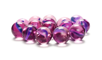 Pile of purple glass marbles, isolated on white background