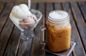 Iced Coffee with Ice Creams on wooden table, selective focus on Coffee Cup, Summer Dessert