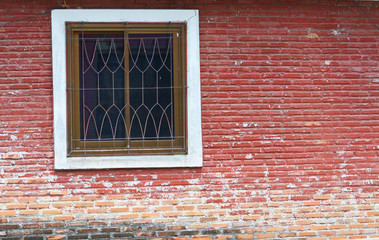 Red brick wall with a window.