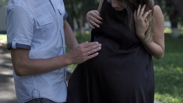 A man stroking his wife's pregnant belly