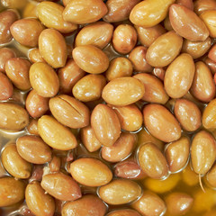 organic green olives in brine top view, tasty background