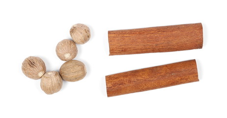 Cinnamon sticks with nutmeg nuts isolated on white background, top view