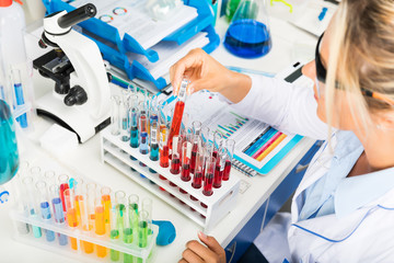 Young attractive woman scientist working with test tubes in the laboratory