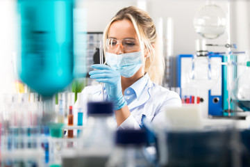 Young attractive female scientist preparing laboratory equipment for tests