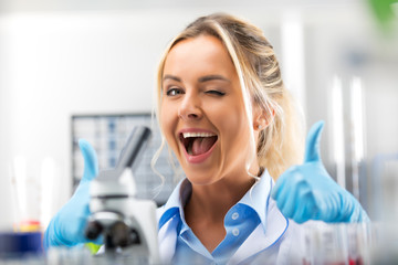 Young attractive smiling woman scientist is happy with her work