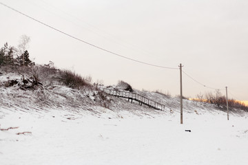 Beach frozen stream. Staircase. Winter landscape