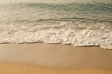 Close up tropical beach with smooth wave and sand texture background.