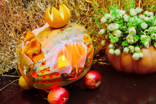 Halloween. A curly head with a burning candle on the foton of the hayloft. The Feast of the Dead. Pumpkin. Ornaments from pumpkins