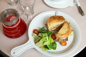 A cuted burger on plate with cranberry tea