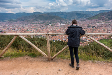 Fototapeta na wymiar Touristin geniesst Aussicht auf Cusco von Sacsayhuamán