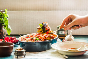 Ratatouille in a crockery on blue rustic background, serving a meal. .Classic French stew of autumn vegetables.