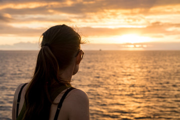 Frau blickt in den Sonnenuntergang, Galapagos