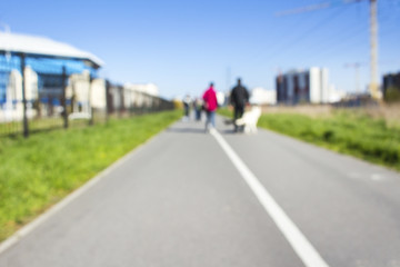 Two people are walking along the road blurred background