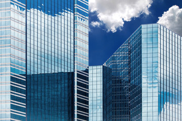 Blue sky and clouds reflecting in windows of modern office building