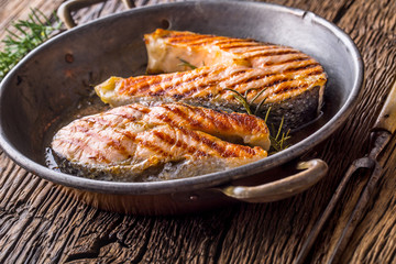 Salmon. Grilled fish salmon. Grilled  salmon steak in roasted pan on rustic wooden table