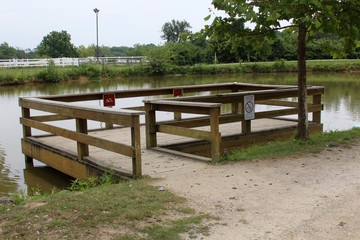 The fishing dock at the lake in the park.