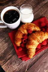 Coffee white cup, croissants on brown wooden background. Breakfa