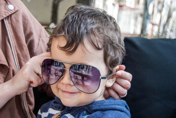 little boy trying on sunglasses