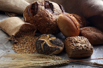 Different kinds of bread and bread rolls on board. Kitchen or bakery poster design.