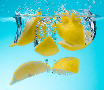 Lemon Slices with water splash on blue background