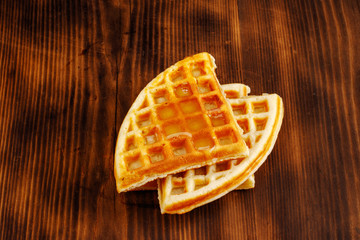 Waffles with honey, jam, and berries on wooden background