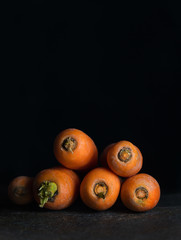 Carrots on the black surface against black background