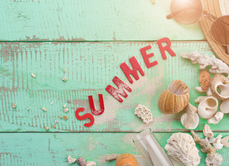 Summer background,Sand and seashells with SUMMER word made from red wooden letters