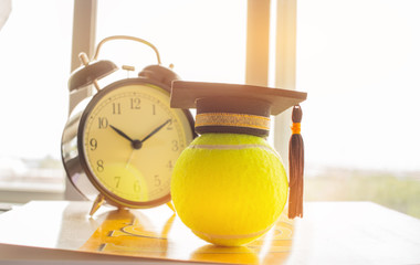 Graduation cap Put on Ball with clock, Tennis is a racket sport can be played individually against...
