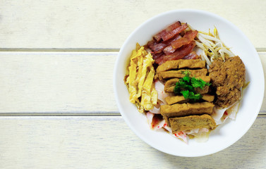 china noodle style with egg, sausage, tofu, pork ontop with gray sauce