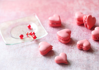 Pink Macaron Hearts with Red Currant Filling, on light pink background.