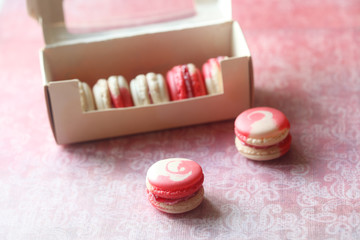Two-colored Macarons, on light pink background.