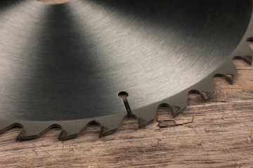Circular saw lies on a wooden surface. Close-up.