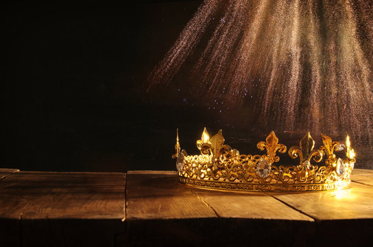 low key of beautiful queen/king crown over wooden table. vintage filtered. fantasy medieval period