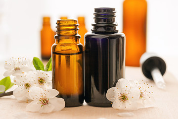 Two bottles of essential oil with cherry blossoms
