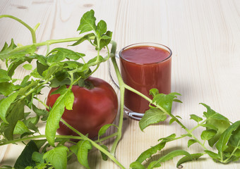 Red ripe tomato with leaves and tomato juice