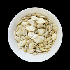 Pumpkin seeds bowl isolated on black
