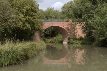 Fototapeta na wymiar Brick built bridge crossing a river