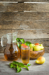 Pears in a wooden dish and a carafe of pear juice