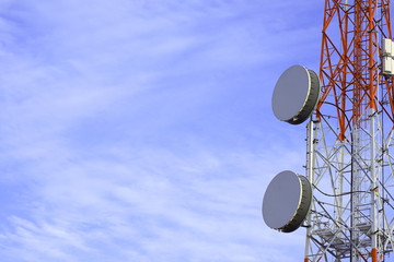 communications tower with satellite microwave dishes , telephone transceiver on pole and blue sky background               