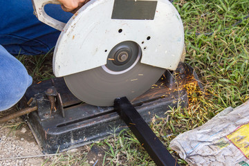 Mechanic using saw machine cutting steel.