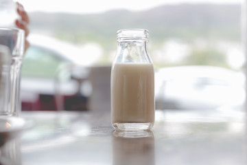 Open very small vintage retro glass bottle of milk with milk inside