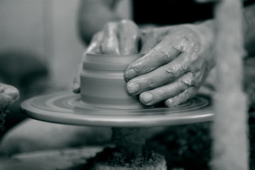 A potters hands guiding with the ceramic wheel