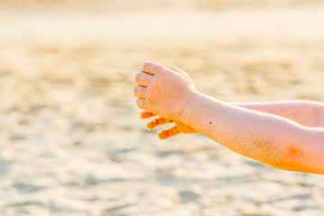 Fototapeta na wymiar baby hands playing with sand on the beach