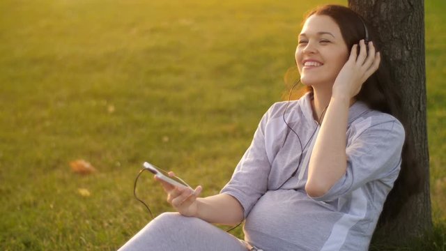 Pregnant Woman listening to music on nature
