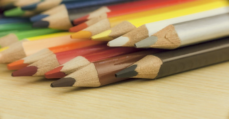 Fototapeta premium A set of colored pencils over a table. Side view. Concept: back to school. 