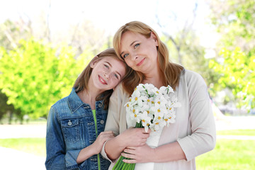 Cute girl with her grandmother in spring park on sunny day