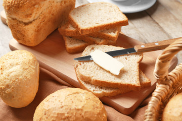 Delicious bread slices and piece of butter on wooden table