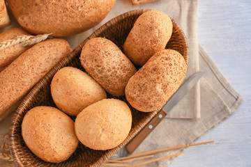 Wicker basket and delicious bread on wooden table