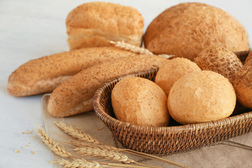 Wicker basket and delicious bread on wooden table